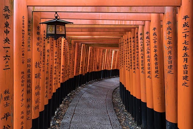 Torii path with lantern at Fushimi Inari Taisha, Kyoto. Image by Basile Morin - Own work, CC BY-SA 4.0